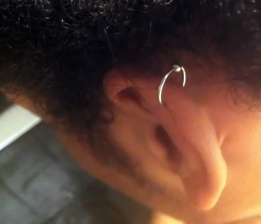 A silver captive bead ring through the helix