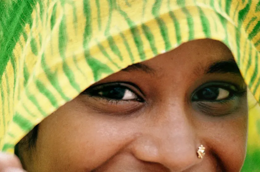 A healed nostril piercing with a small gold stud, the skin around it flat and unmarked