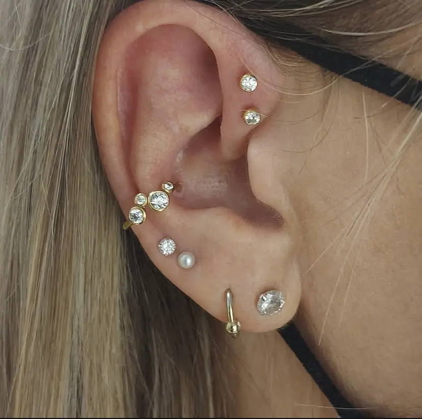 Stacked lobe piercings below helix and flat piercings on one ear