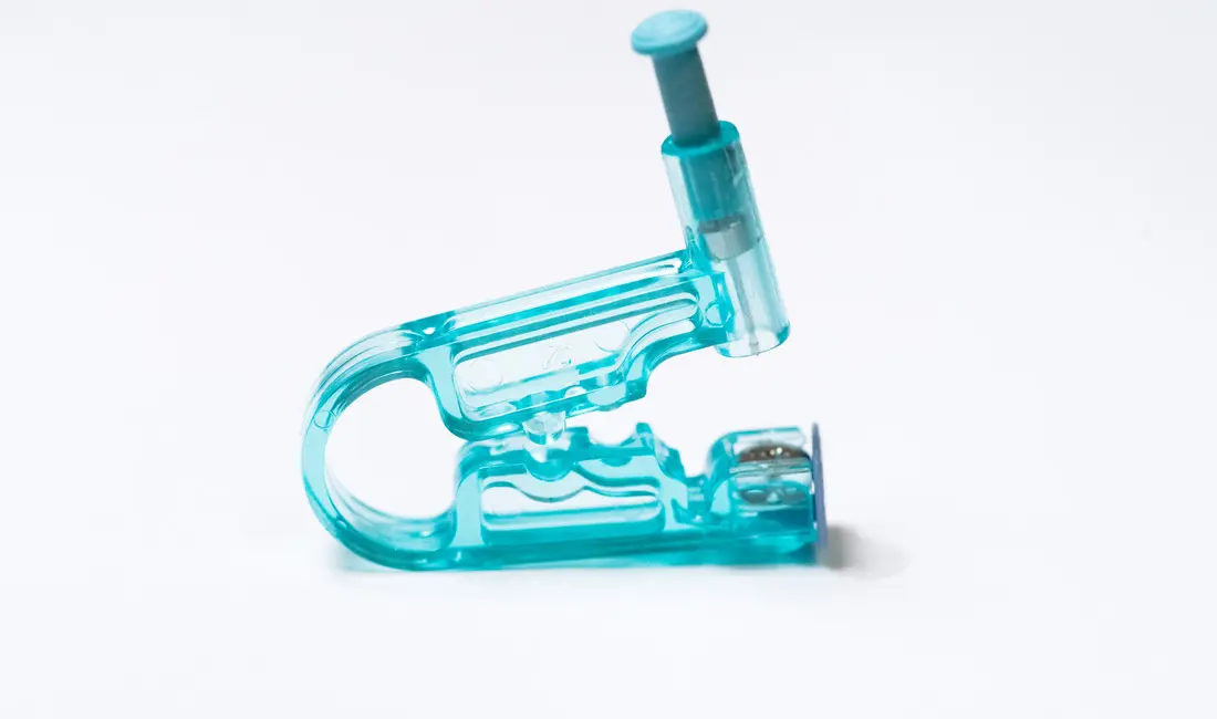 A disposable single-use ear piercing gun loaded with a stud cartridge