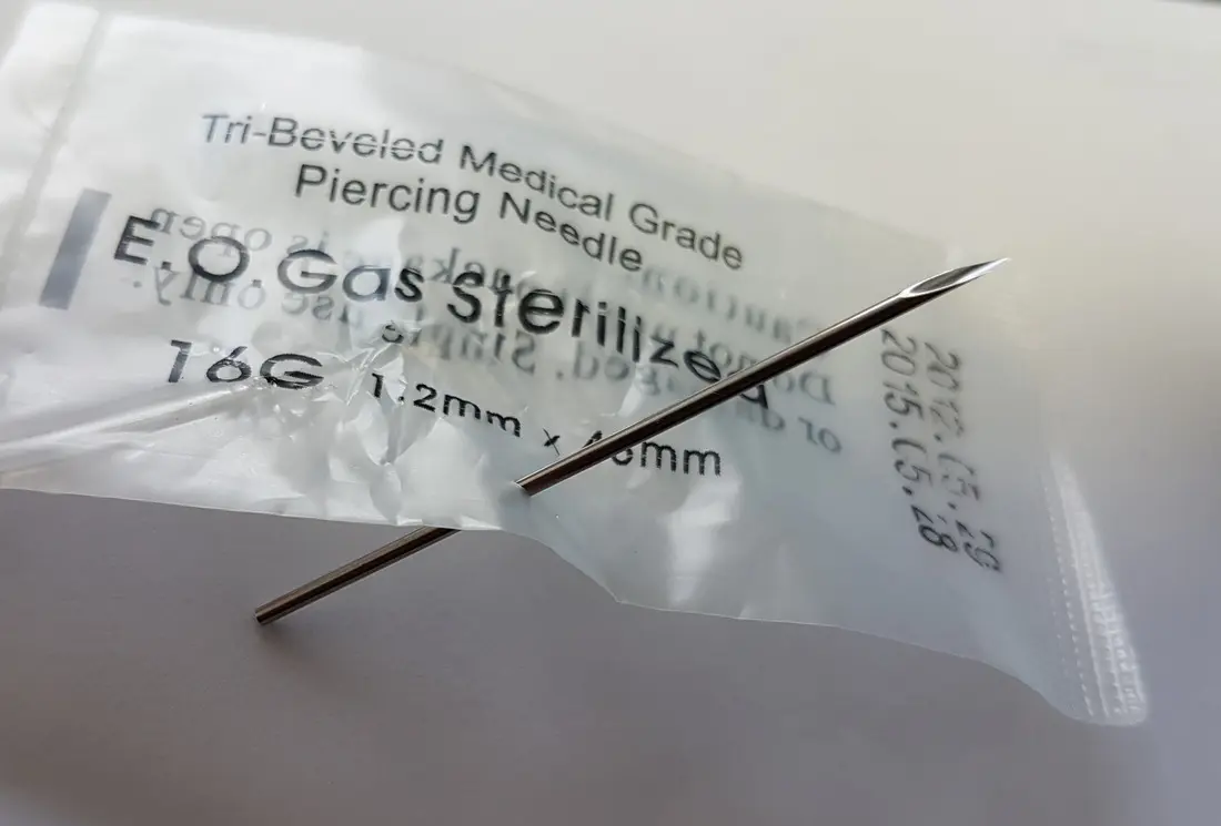 A sterile 16 gauge piercing needle in its sealed, gas-sterilised packet
