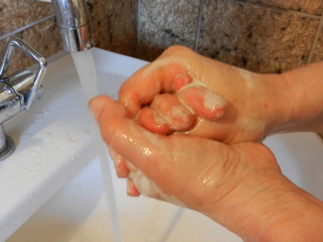 Hands being lathered with soap under running water, the first step of every piercing clean